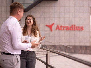 Woman and man have coffee break outside at the entrance of the Cardiff office