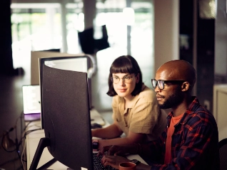 Male and female compute analysts working in front of computer