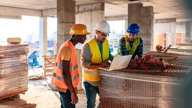 Construction workers on a building site reviewing site plans